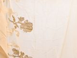 a white curtain with gold designs on it