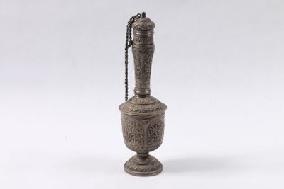 un vieux vase en métal dont le col est orné d'une chaîne