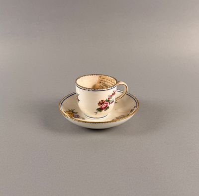 une petite tasse posée sur une soucoupe