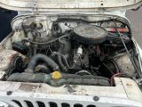 a white jeep with an engine in the back of it