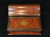 an antique wooden box with a brass - plated lid on a black background