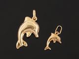 a pair of gold dolphin pendants on a black background