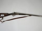 an old rifle with a wooden handle and a leather strap