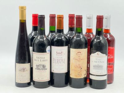 plusieurs bouteilles de vin sont alignées sur une surface blanche