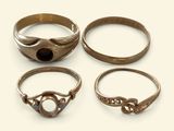 three rings with a stone in the middle of them on a white surface