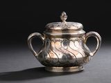 une théière ancienne en argent avec son couvercle, posée sur une table