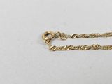 a close up of a gold chain on a white surface