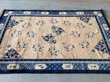 an image of a blue and beige oriental rug on the floor
