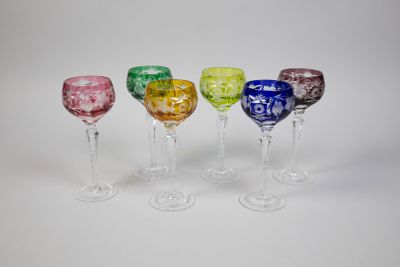 quatre verres à vin de couleurs différentes sont alignés en rangée