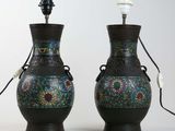 pair of asian vases with floral designs on them sitting on a white surface