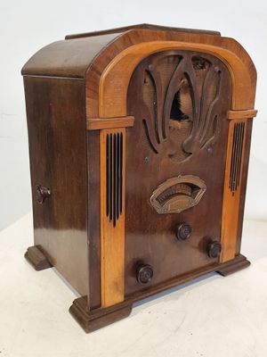 une vieille radio en bois posée sur une table blanche