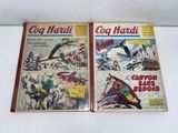 two comic books are sitting on a white surface