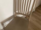 a wooden chair sitting in front of a white wall