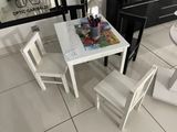 une petite table et deux chaises dans une petite pièce