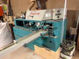 une photo d'une machine en train de scier un morceau de bois