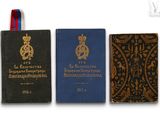 trois livres sont alignés sur une surface blanche, avec un ruban bleu