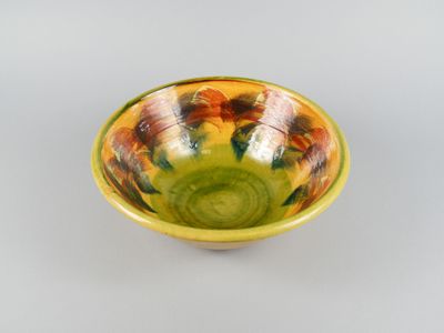 yellow and green bowl sitting on top of a white table