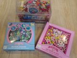 deux boîtes de bonbons et une boîte de perles posées sur une table