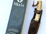 un couteau posé à côté d'une boîte de muelaa