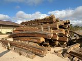 a pile of wood sitting on the ground in front of a house