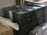 une pile de caisses noires posée sur un tas de cartons