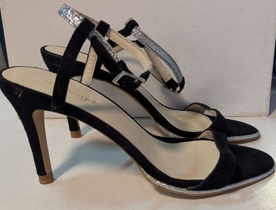 chaussures à talons hauts noires et argentées, ornées d'un nœud sur la pointe