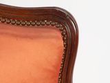 a chair that has a red upholstered cushion on it