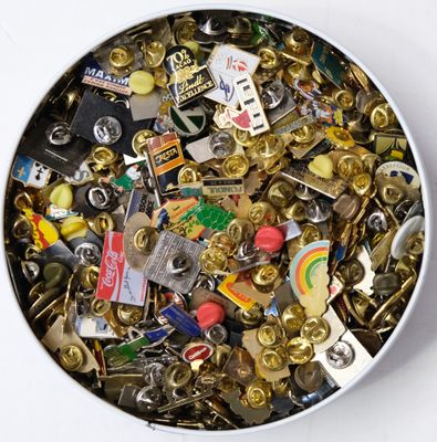 a white bowl filled with lots of different types of pins