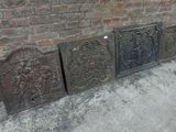 trois vieilles grilles de cheminée en fonte posées sur le trottoir