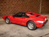 a red sports car parked in front of a brick wall