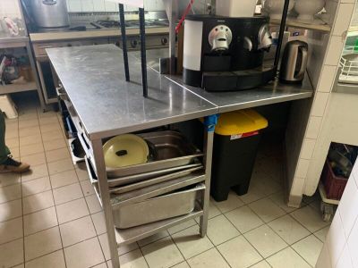une cuisine avec des plans de travail en inox et un évier