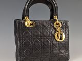 un sac à main noir avec des finitions dorées sur la poignée
