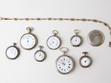 many different types of pocket watches displayed on the wall