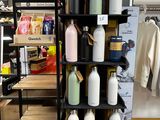 une étagère noire sur laquelle sont disposées de nombreuses bouteilles dans un magasin