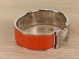 an orange bracelet sitting on top of a wooden table