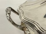 a silver plate with a handle on a table