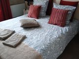 un lit avec des oreillers et des couvertures dans une chambre à coucher