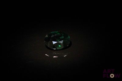 gros plan d'un diamant vert sur une surface noire