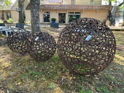 trois boules métalliques posées dans l'herbe