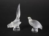 deux oiseaux en verre transparent posés sur une surface noire