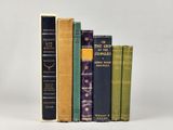 plusieurs vieux livres sont empilés sur une surface blanche
