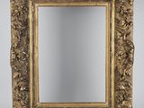 un miroir orné d'un cadre doré au motif floral