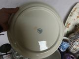 a person holding a white plate on top of a table