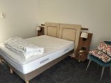 a bed with a white sheet on top of it in a room