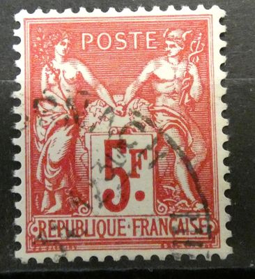 un vieux timbre rouge et blanc sur lequel figure l'image d'une femme