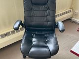 a black office chair sitting in front of a window