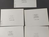 four white envelopes are sitting on top of a black table