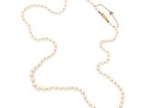 un collier de perles avec un fermoir en or sur fond blanc