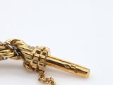 a close up of a gold necklace with a chain on it