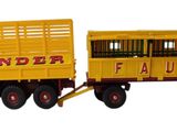 un camion rouge auquel est attelée une remorque jaune